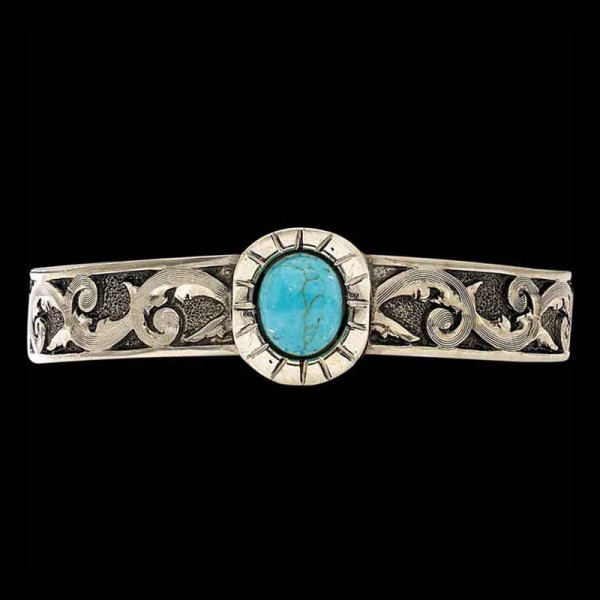 Every Cowgirl loves Turquoise! This cuff bracelet is crafted on a German Silver base with a matted base and antique finish. Detailed with a Beautiful Turquoise Stone in the center. 6" x .5"

Pair with a Cow Tag Necklace or a Custom Belt Buckle